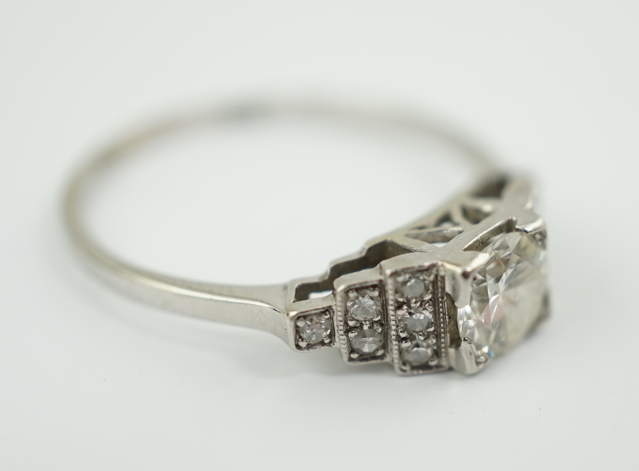 An Art Deco 18ct white gold, platinum and single stone diamond ring, with twelve stone diamond chip set stepped shoulders